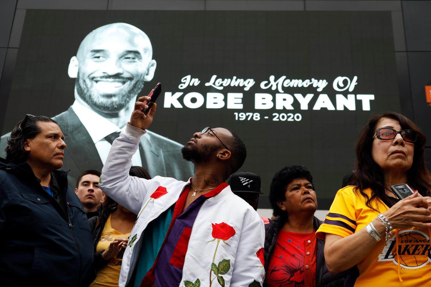 Fans gather near a makeshift memorial for Kobe Bryant outside Staples Center after learning of the Lakers legend's death Sunday.