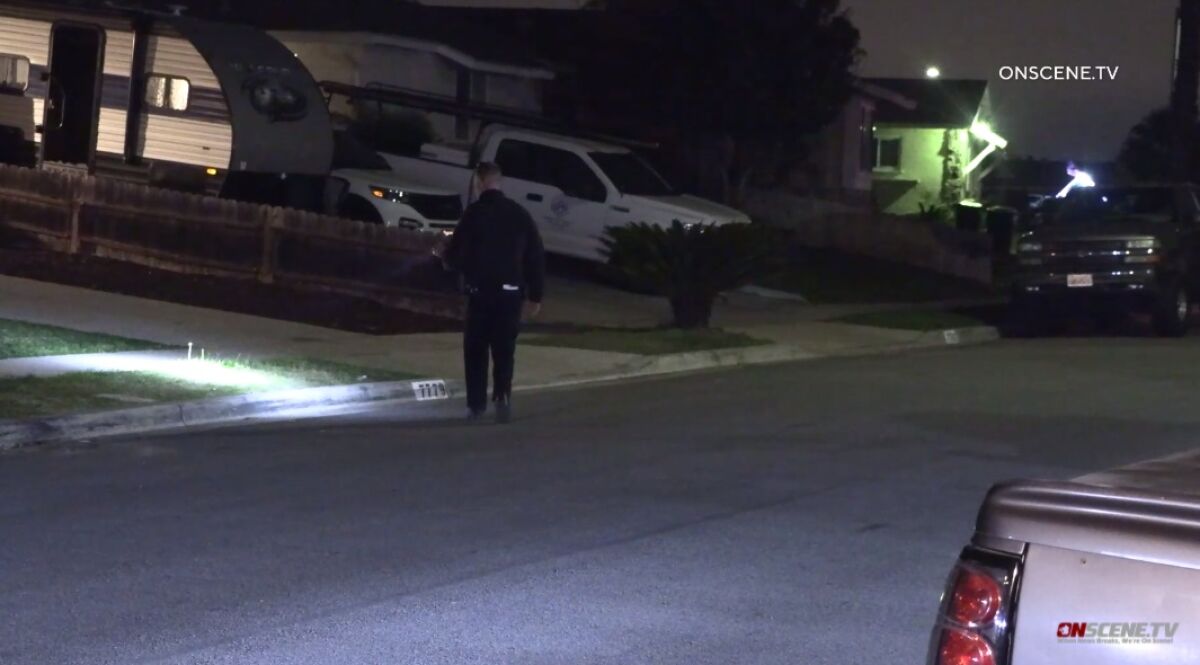 A San Diego police officer searches for evidence of a shooting Friday night in Bay Terraces.