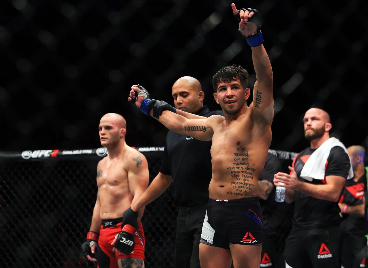 Matthew Lopez raises his arms in triumph after defeating Mitch Gagnon in a bantamweight fight at UFC 206 in Toronto.
