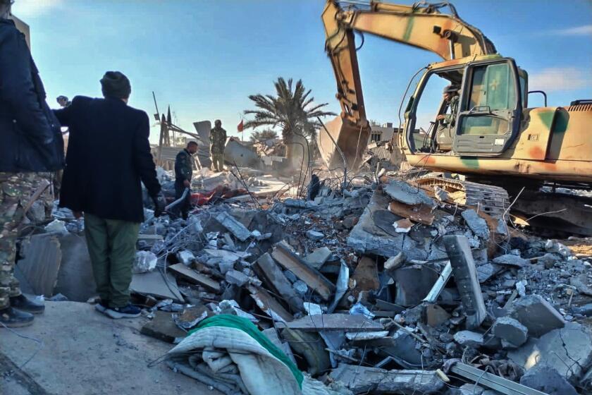 Members of Iraqi Shiite Popular Mobilization Forces clean the rubble after a U.S. airstrike in al-Qaim, Iraq, Saturday, Feb. 3, 2024. The U.S. Central Command said in a statement on Friday that the U.S. forces conducted airstrikes on more than 85 targets in Iraq and Syria against Iran's Islamic Revolutionary Guards Corps and affiliated militia groups. (AP Photo/Popular Mobilization Forces Media Office)