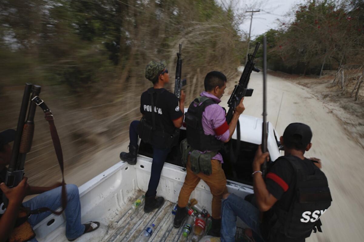 Miembros de un grupo de autodefensas patrullan una carretera.