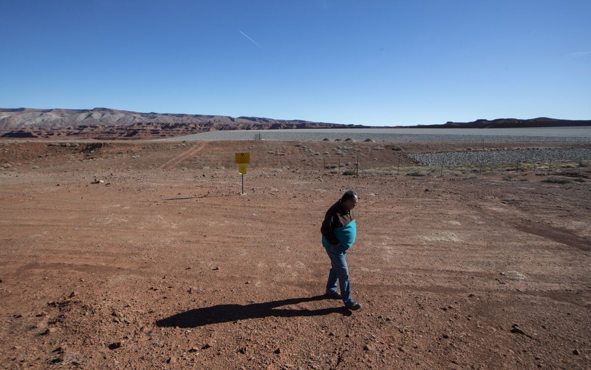 Jonah Yellowman walks along the edge a repository for radioactive material from a now-defunct uranium mill near Mexican Hat, Utah.