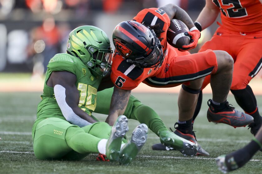 Oregon State running back Damien Martinez (6) is brought down by Oregon defensive back Jamal Hill (19) during the first half of an NCAA college football game on Saturday, Nov 26, 2022, in Corvallis, Ore. (AP Photo/Amanda Loman)