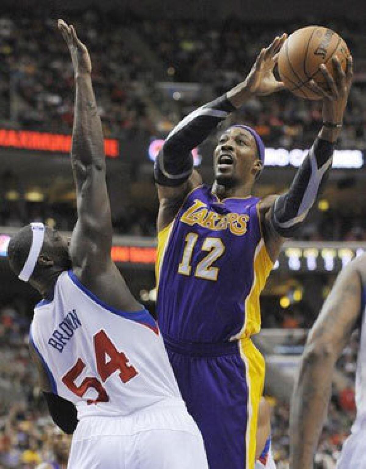 Dwight Howard shoots over Sixers big man Kwame Brown