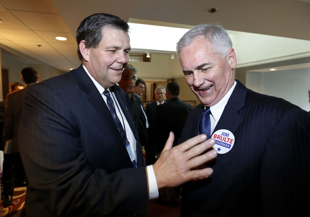 Jim Brulte, the new leader of the California Republican Party, places a campaign sticker on GOP Rep. Tom McClintock, at the California Republican Party convention on Saturday.