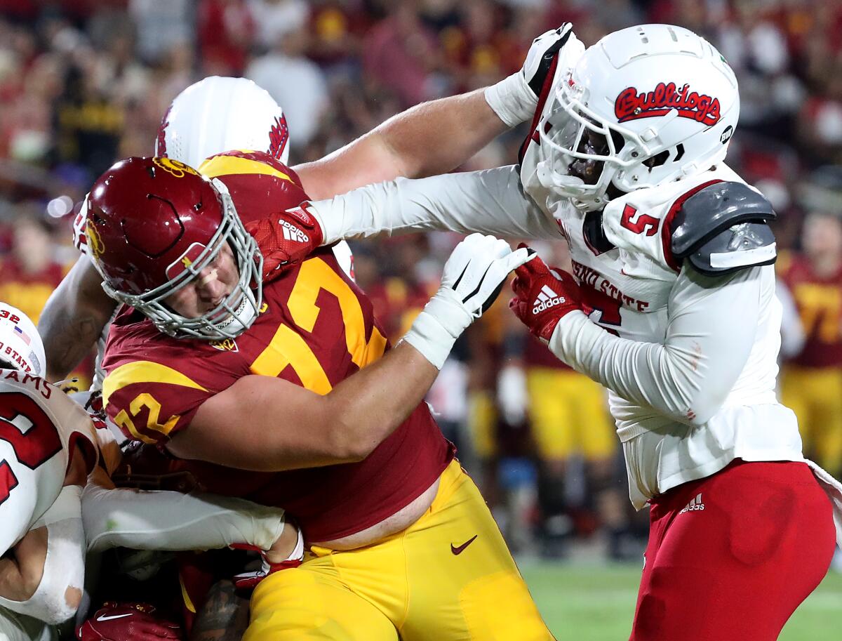 USC offensive lineman Andrew Vorhees, left, and Fresno State defensive back Alzillion Hamiltonin get physical.