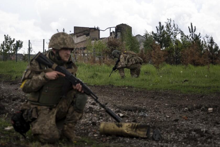 Ukrainian servicemen on patrol in a recently retaken village