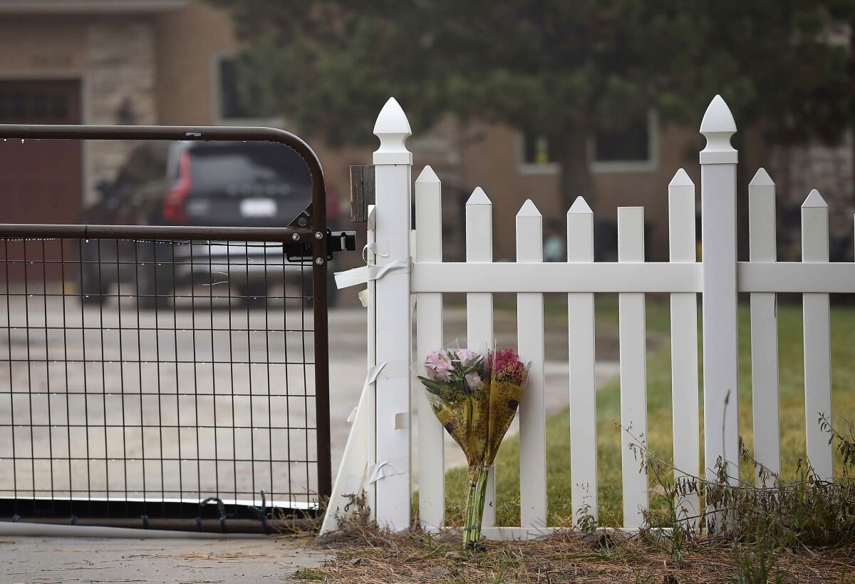 Flowers rest against the gate of a white picket fence on Sunday, Oct. 31, 2021, outside a home where four dead bodies were found a day earlier in Gleneagle, near Monument, Colo. Two children and two adults were killed in what appears to be a murder-suicide at the home, the El Paso County Sheriff’s office said Sunday. (Jerilee Bennett/The Gazette via AP)