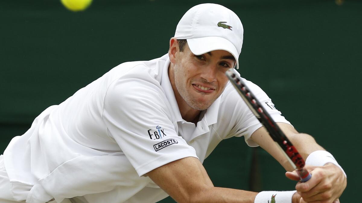 John Isner plays a return during his loss to Feliciano Lopez at Wimbledon on Monday.