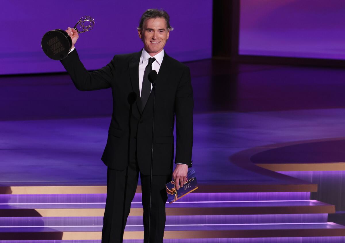 Billy Crudup holds an Emmy on stage