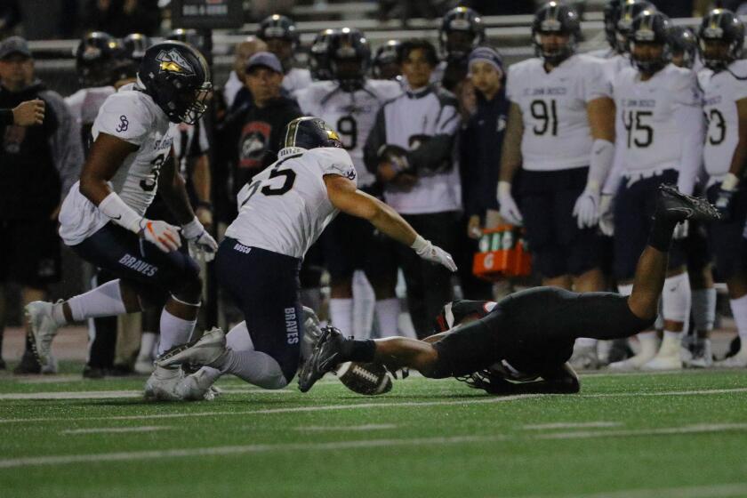 CORONA CA - NOVEMBER 22, 2019: Corona Centennial running back Nicholas Floyd (22) loses the ball on a wide pitch-out as St. John Bosco defensive end Nathan Burrell (36) and linebacker Danny Lockhart (55) come in for the recovery in the first half on November 22, 2019 in Corona, California. (Gina Ferazzi/Los AngelesTimes)