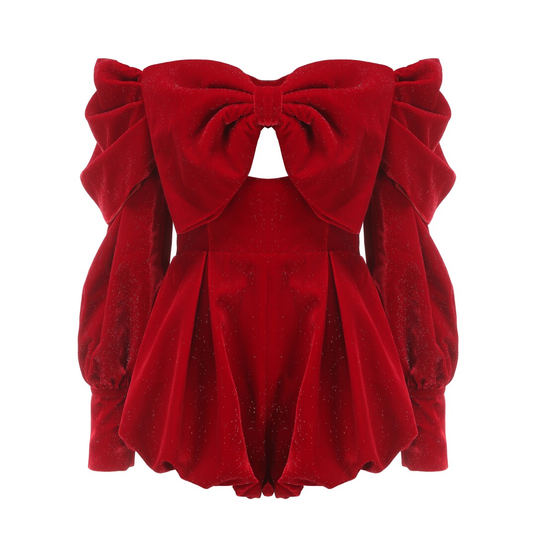 A red ruffled jumpsuit with long sleeves and short legs with a knot neckline.