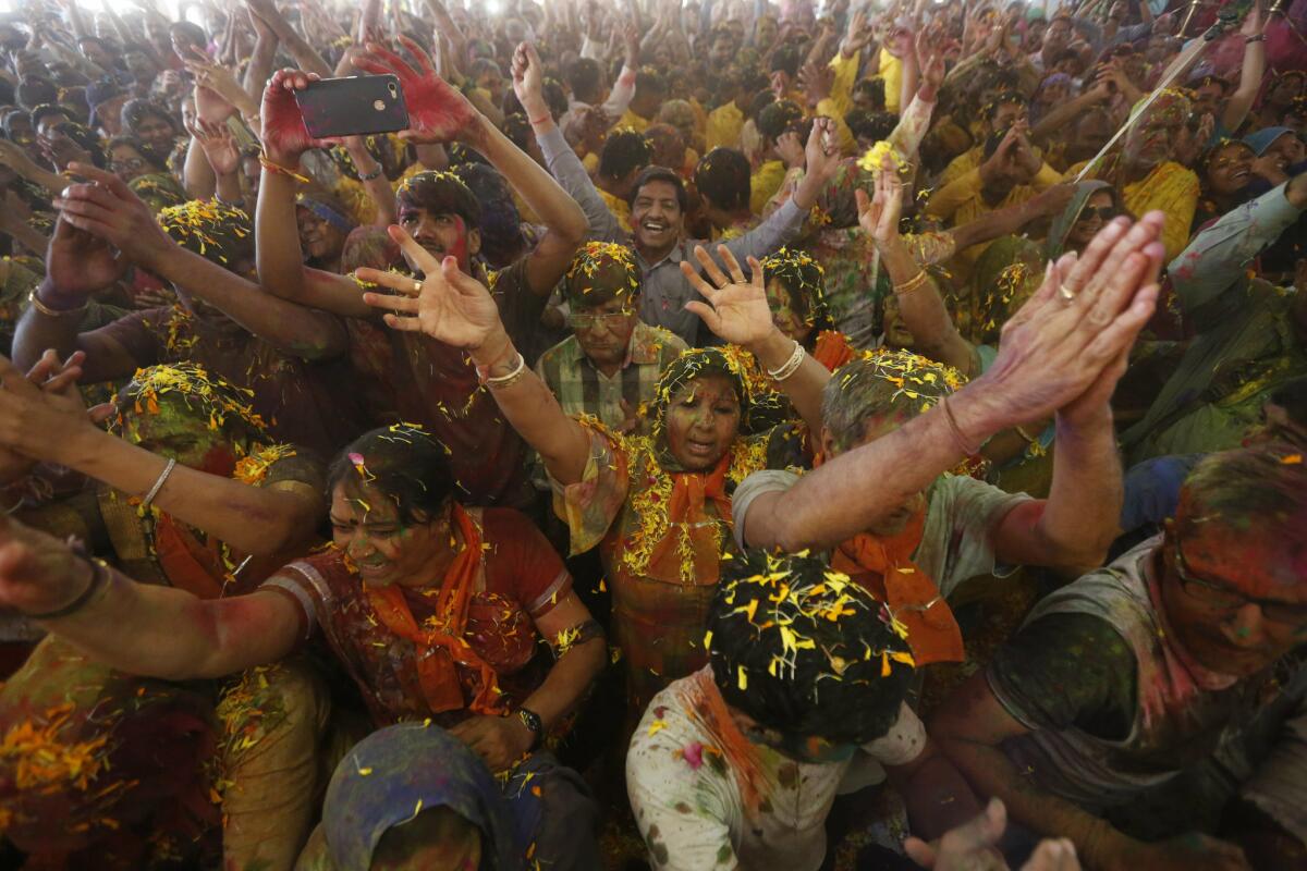 Hindu devotees dance as colored powder and flowers are thrown on them during a Holi festival celebration at the Lord Jagannath temple in Ahmedabad, India. (Ajit Solanki / Associated Press)