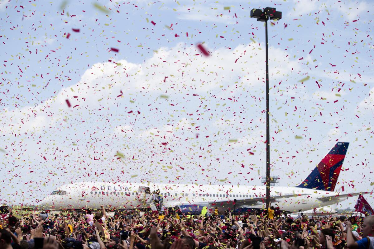 Confetti is sprayed over the crowd as the Cleveland Cavaliers arrive at the airport. (John Minchillo / Associated Press)