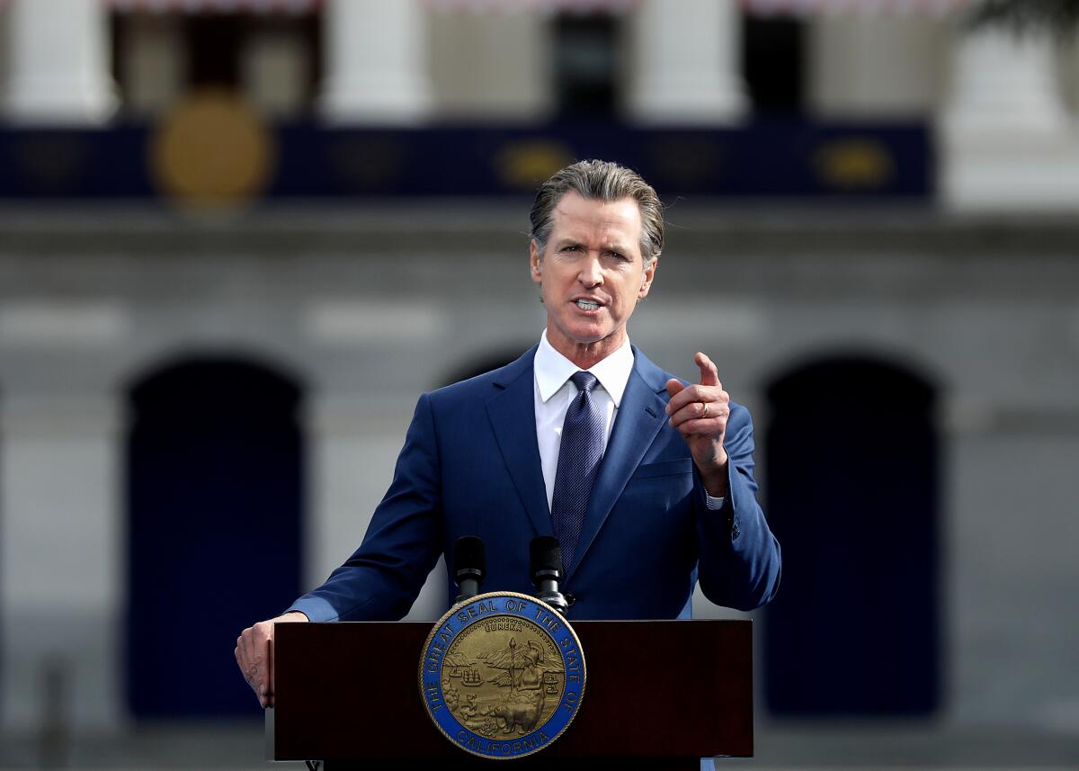 Gov. Gavin Newsom talks, gesturing with his left hand, as he gives the inaugural address after taking the oath of office