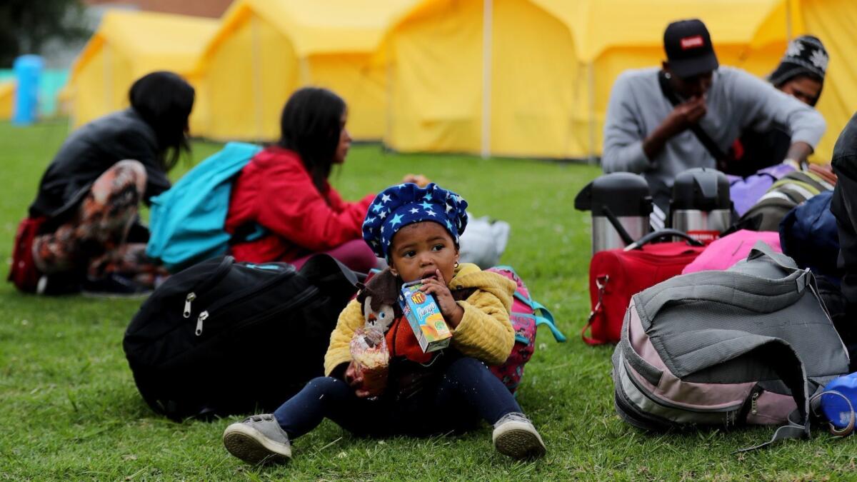 A Venezuelan child drinks juice after being moved by Colombian authorities to a camp in Bogota on Tuesday.