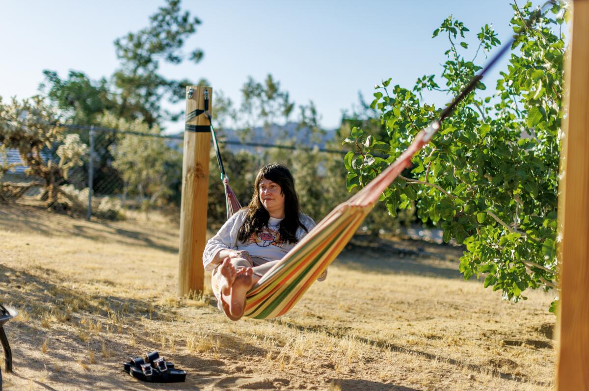 A woman swining in a backyard hammock