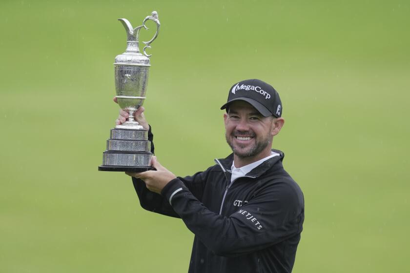 United States' Brian Harman poses for the media as he holds the Claret Jug trophy for winning the British Open Golf Championships at the Royal Liverpool Golf Club in Hoylake, England, Sunday, July 23, 2023. (AP Photo/Kin Cheung)