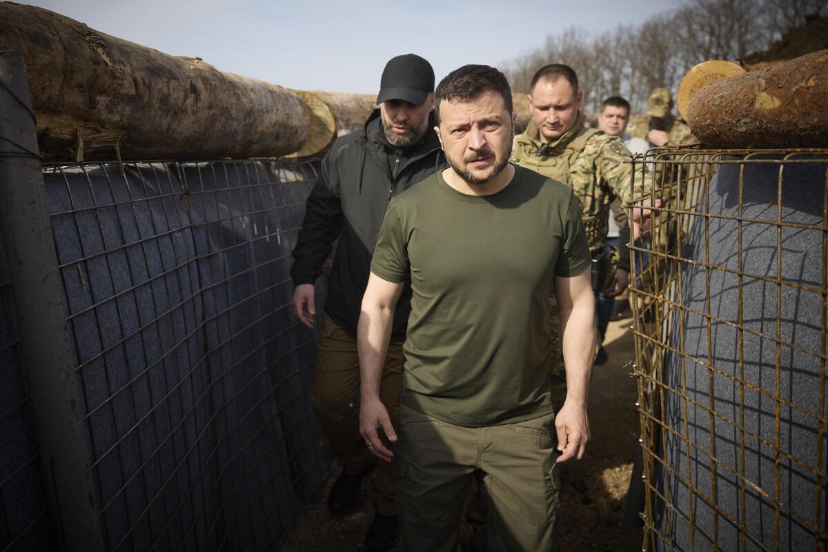 Ukrainian President Volodymyr Zelensky walks through a fortification trench in Kharkiv region, Ukraine.