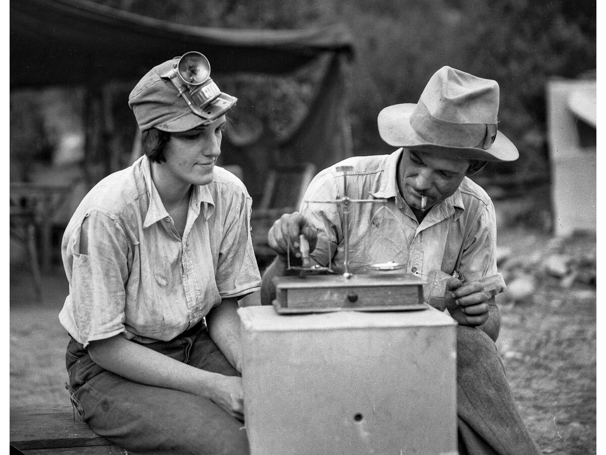 Gold miners Mrs. Frank Robison and Charles T. Brown weigh gold in San Gabriel Canyon. 
