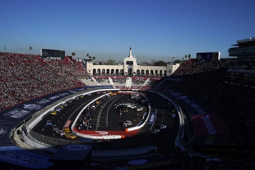 Competitors make a turn during a NASCAR exhibition auto race at Los Angeles Memorial Coliseum, Sunday, Feb. 6, 2022, in Los Angeles. (AP Photo/Marcio Jose Sanchez)