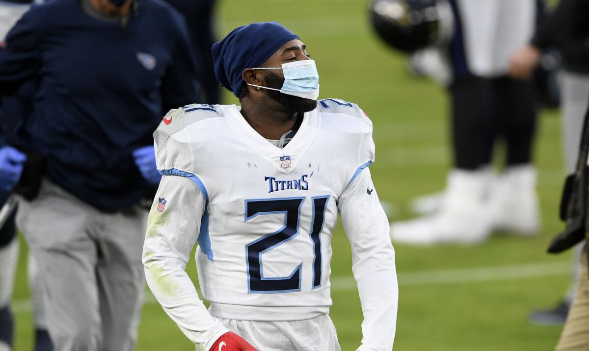 Tennessee Titans cornerback Malcolm Butler walks off the field while wearing a mask.
