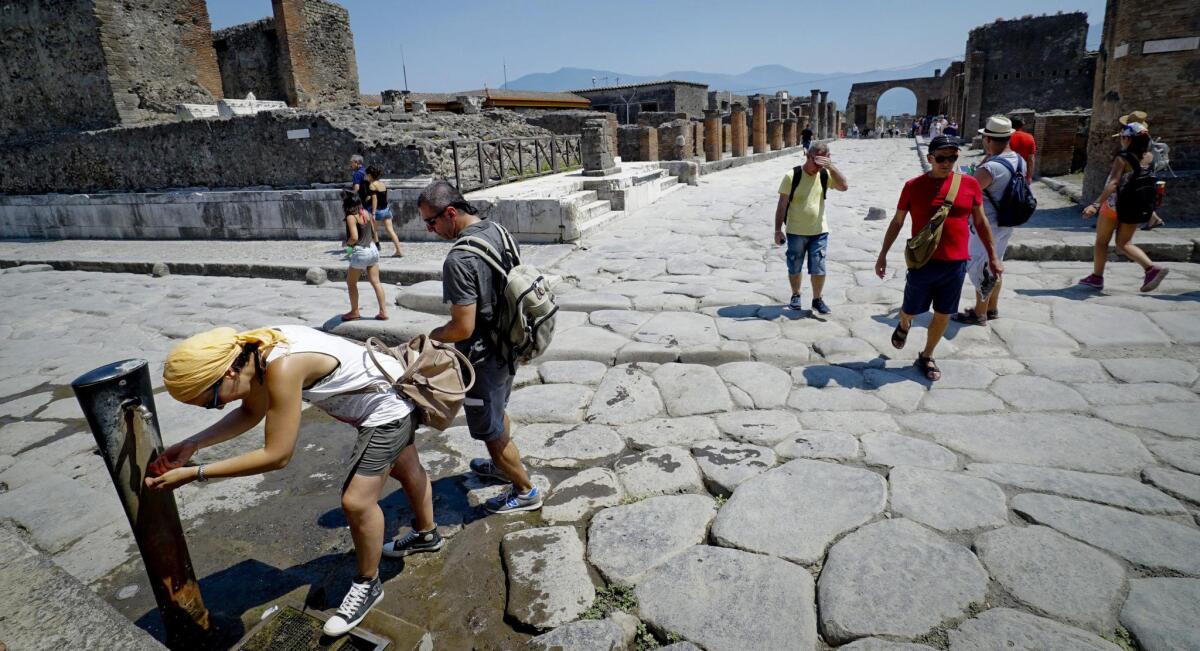 Turistas se refrescan con agua hoy, lunes 20 de julio de 2015, en Pompeya (Italia). La región sufre una ola de calor que puede alcanzar nuevos registros.