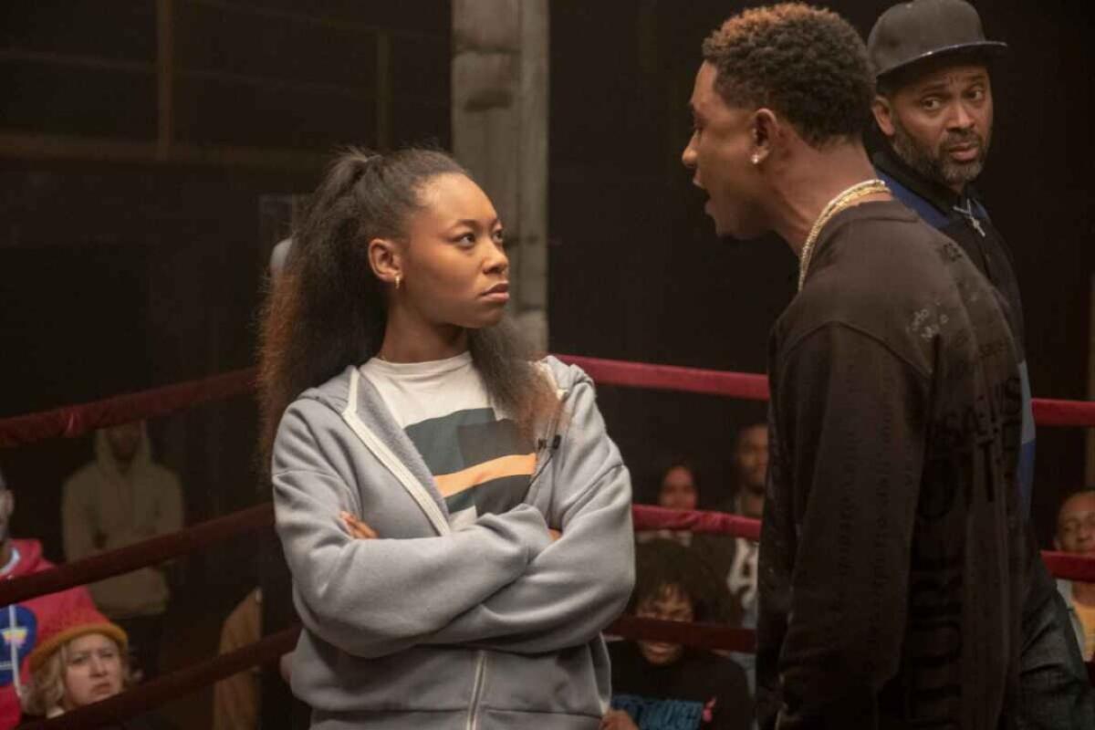 Jamila C. Gray and Justin Martin confront each other on a stage as Mike Epps looks on in the film "On the Come Up."