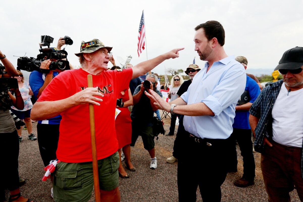 State Rep. Adam Kwasman, right, a tea party candidate seeking the Republican nomination for a congressional seat, in a heated discussion at a protest in Oracle, Ariz.