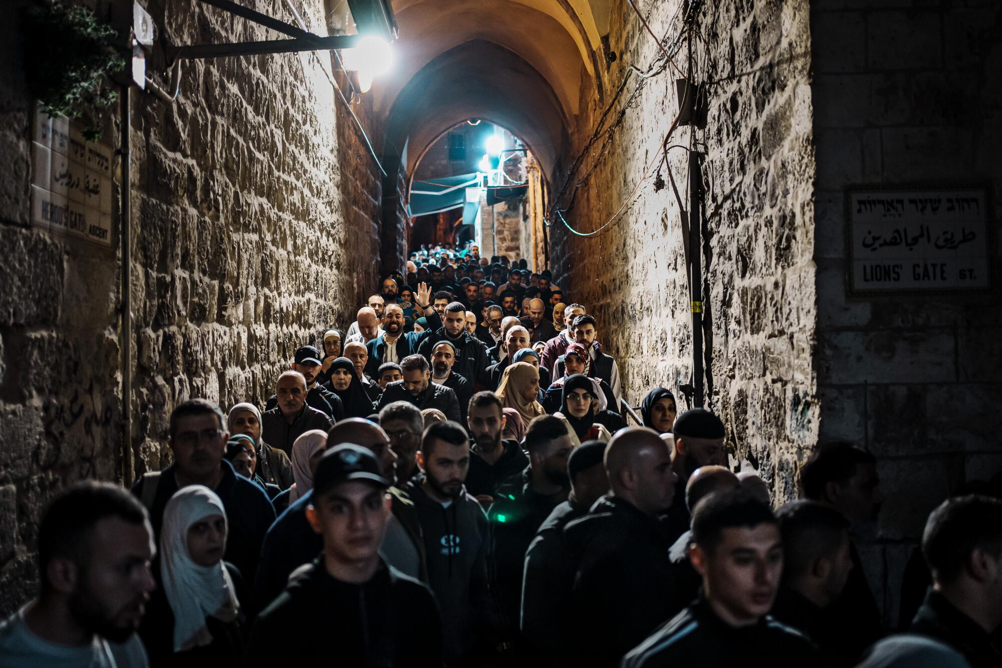 Muslims make their way to Al Aqsa Mosque along a path devoid of Ramadan decorations.