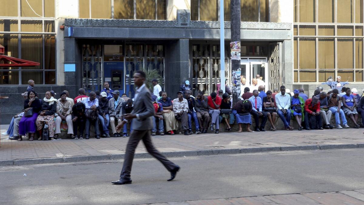Customers wait to make withdrawals from a Barclays bank branch in Harare, Zimbabwe, in 2017.
