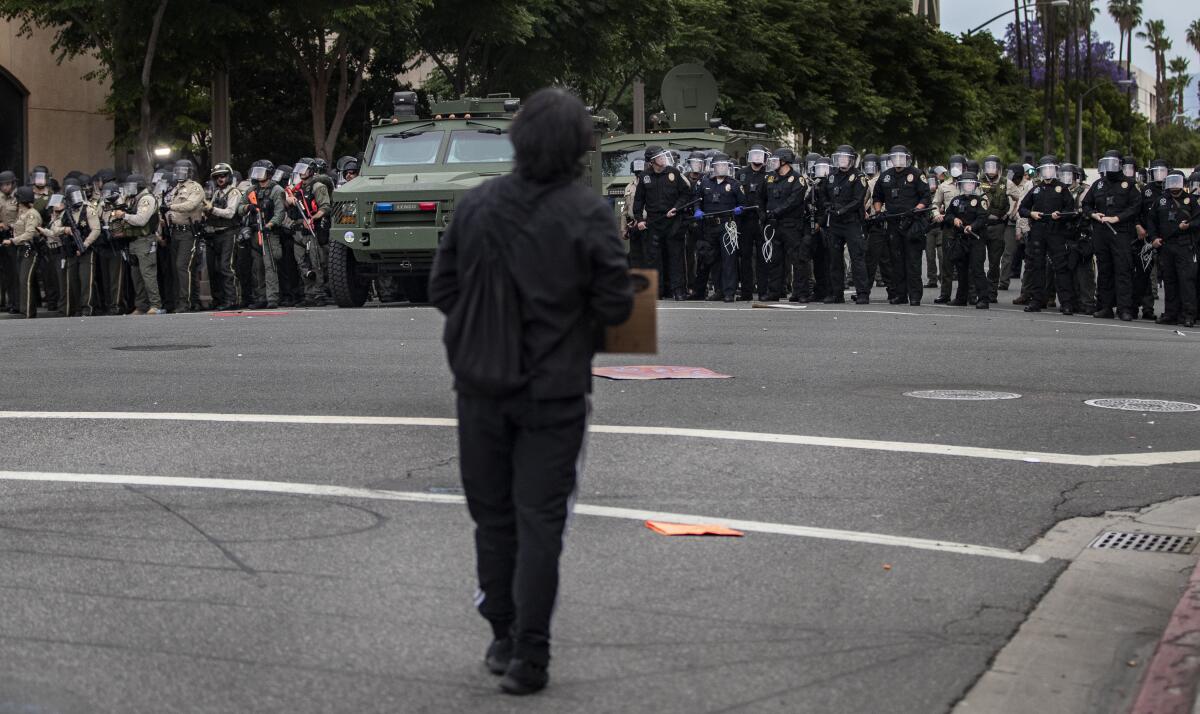 A protester faces a line of law enforcement personnel in Riverside on Monday.