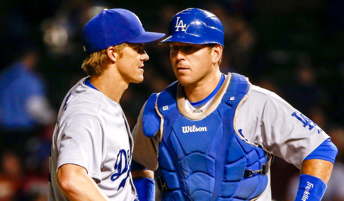 Dodgers pitcher Zack Greinke talks to catcher A.J. Ellis after getting into trouble against the Cubs in the first inning Thursday night in Chicago.
