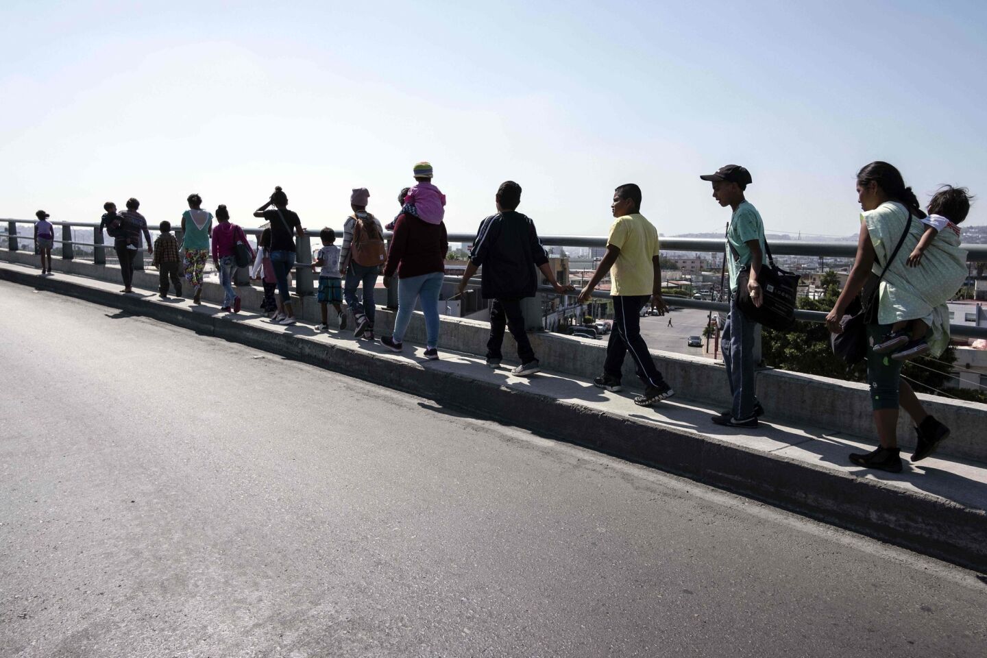 Central American asylum seekers walk to their legal-counsel meetings in Tijuana on Saturday.
