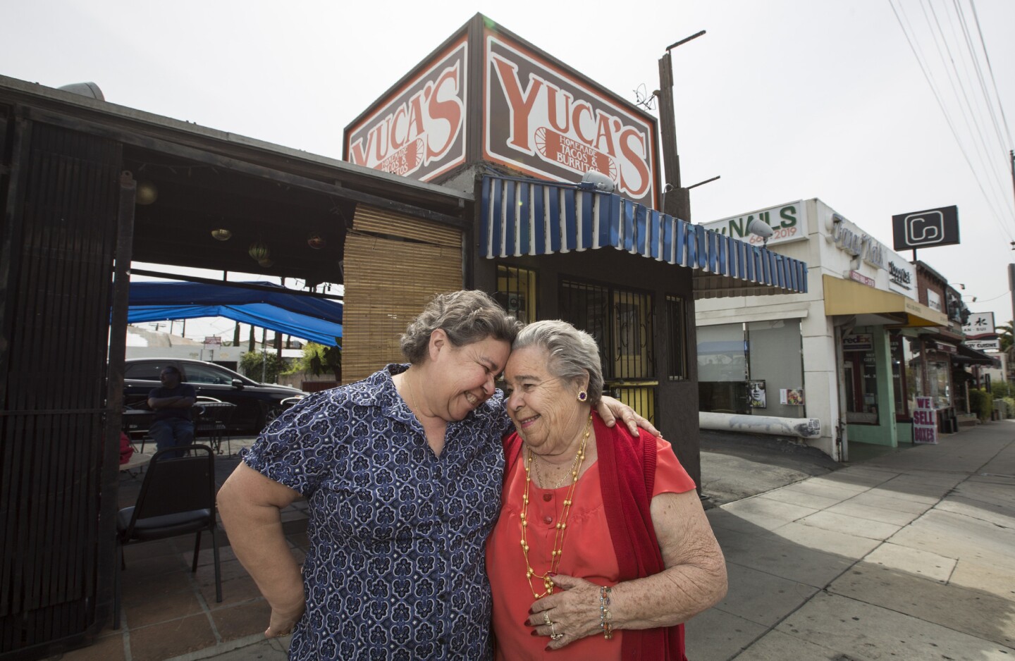 Dora Herrera, left, and her mother Soccoro Herrera put their heads together outside their Yuca's tacos location on Hillhurt Avenue in Los Feliz.