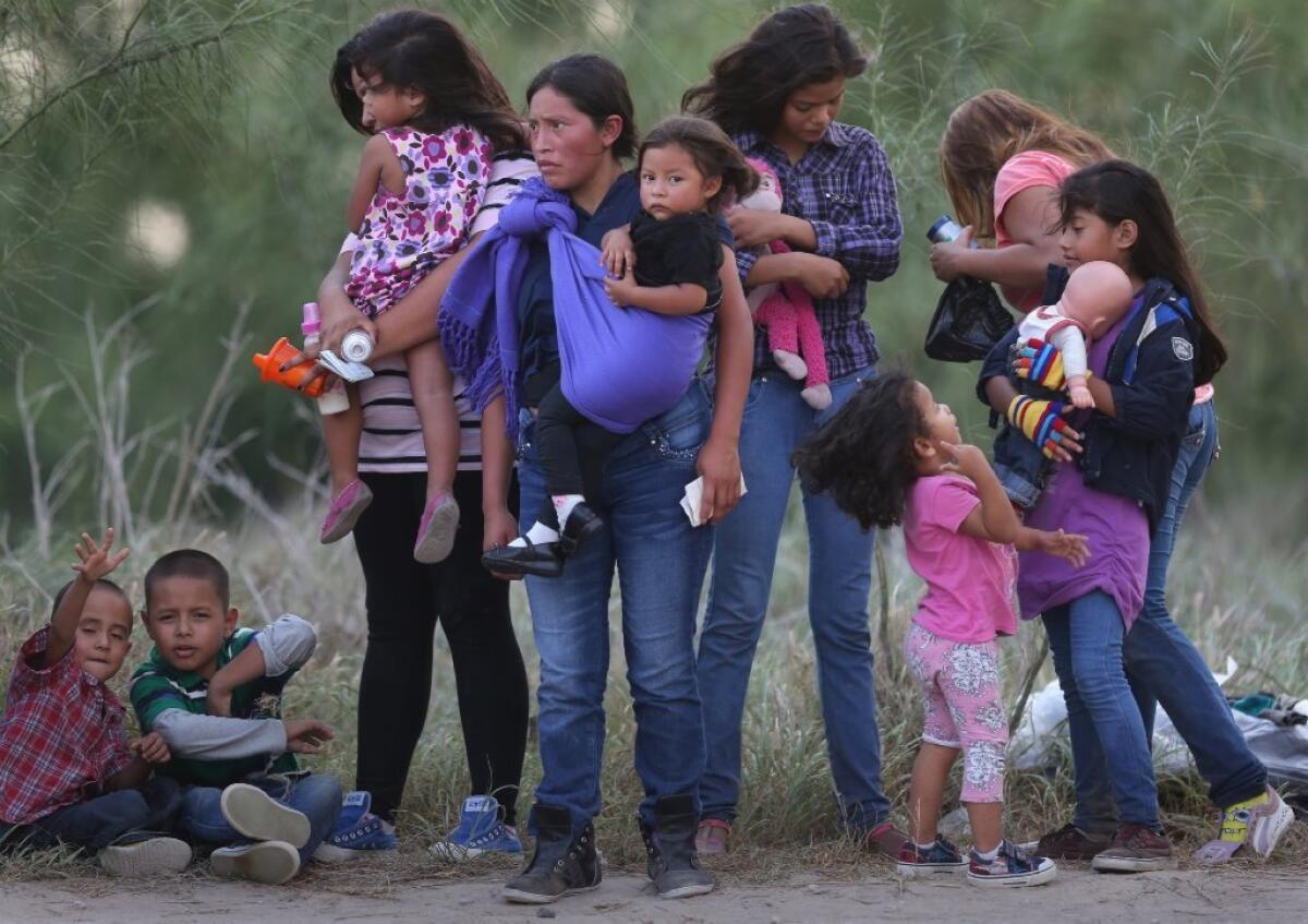 Inmigrantes centroamericanos esperan ser transportados a un centro de procesamiento de la Patrulla Fronteriza de Estados Unidos después de cruzar a Estados Unidos cerca de Mission, Texas.