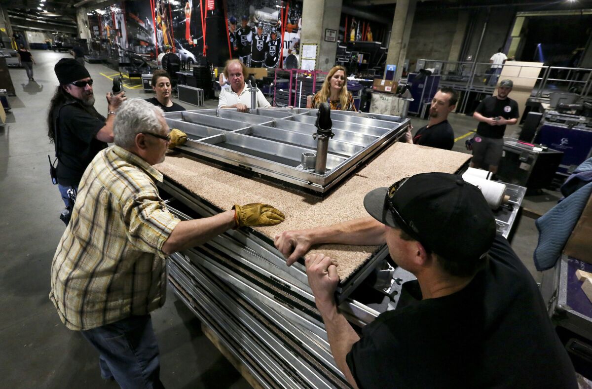 Members of the prop department prepare to move a stage floor that will be used during a performance at the Grammy Awards.