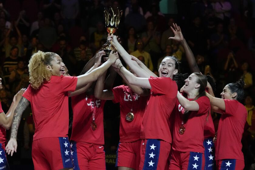 Gold medalists the United States hold their trophy aloft as they celebrate on the podium after defeating China in the final at the women's Basketball World Cup in Sydney, Australia, Saturday, Oct. 1, 2022. (AP Photo/Mark Baker)