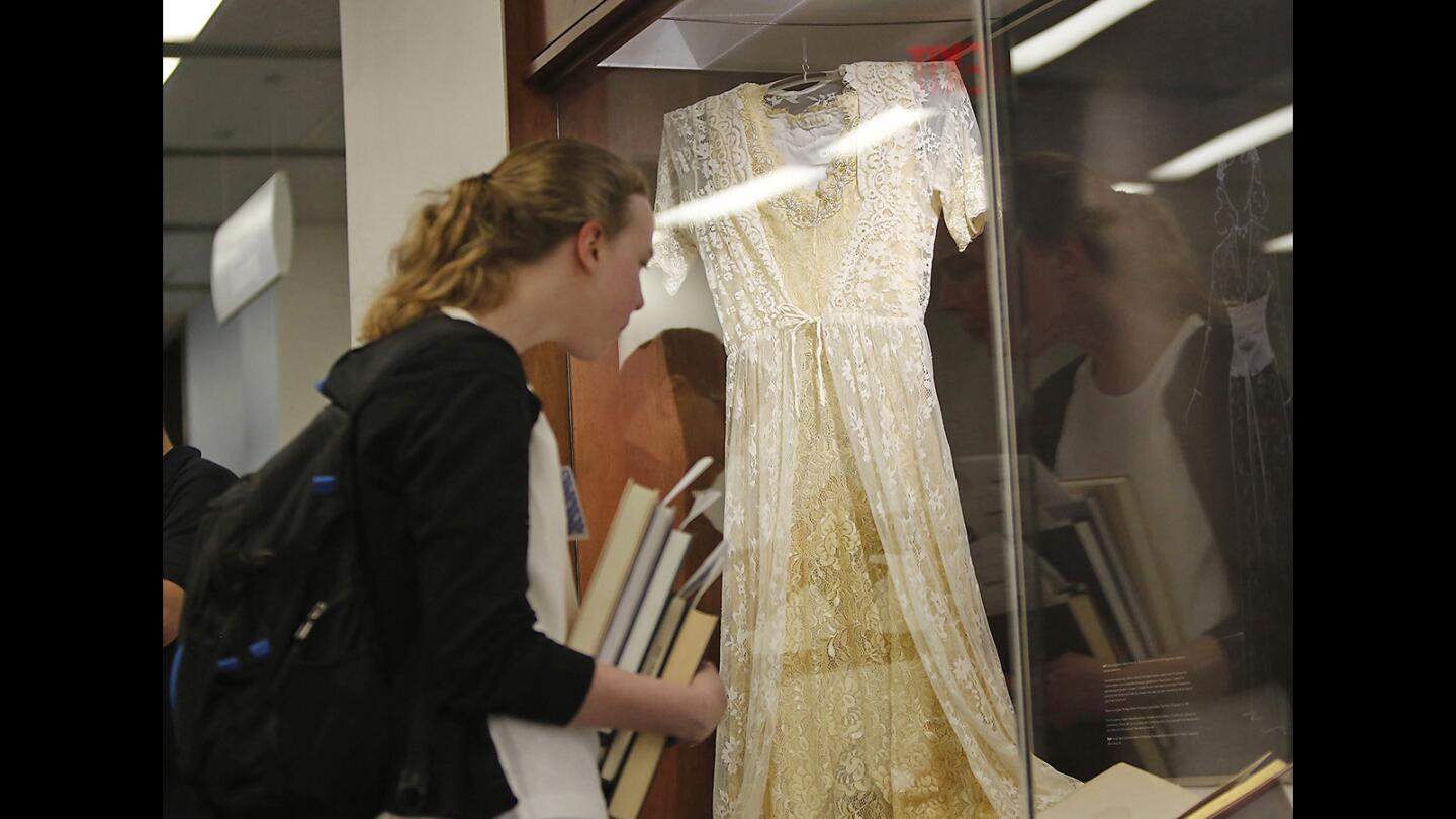 Student Laura Hatch looks at a modern costume designed for Ophelia from Shakespeare's "Hamlet," on display during the opening of "Costuming the Leading Ladies of Shakespeare" at the Muriel Ansley Reynolds gallery at UCI's Langson Library.