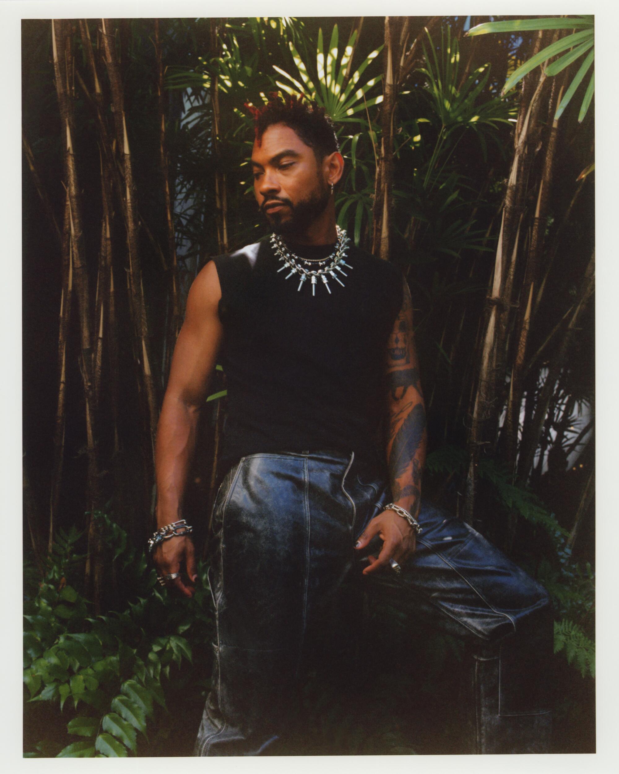 Miguel wears black leather pants, a black tank top and silver jewelry outside the George C. Page Museum.