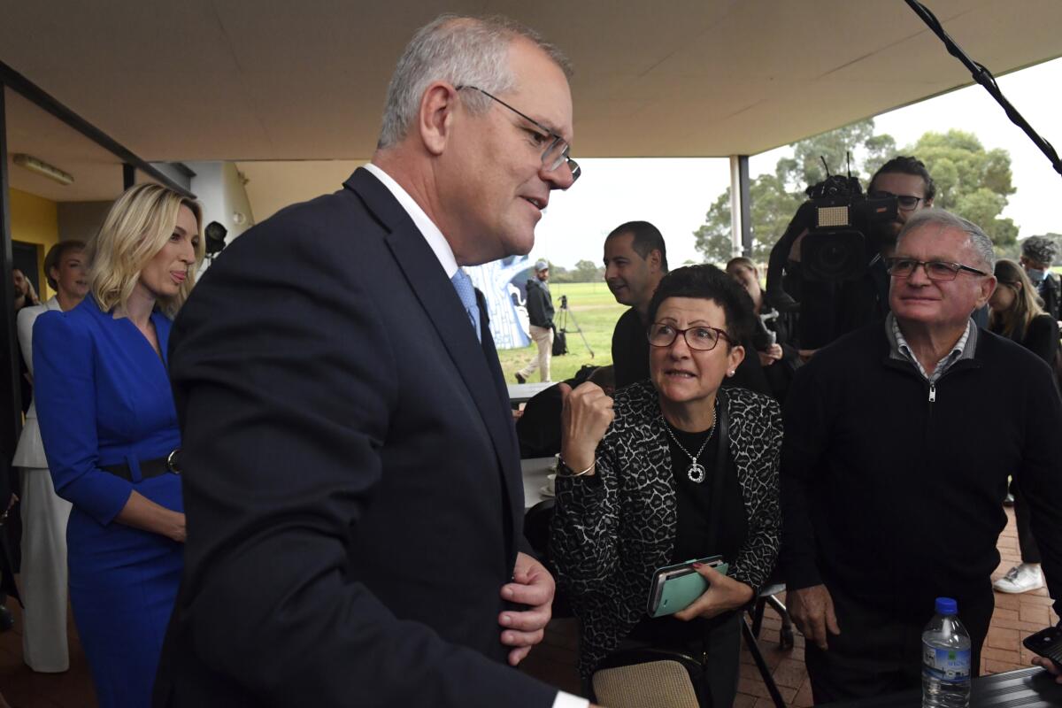 Australia's Prime Minister Scott Morrison speaks with people as he attends a leisure center for a community morning tea while campaigning in Perth, Friday, May 20, 2022. In at least one sense Morrison has become the most successful Australian prime minister in years just by standing for reelection on Saturday. (Mick Tsikas/AAP Image via AP)
