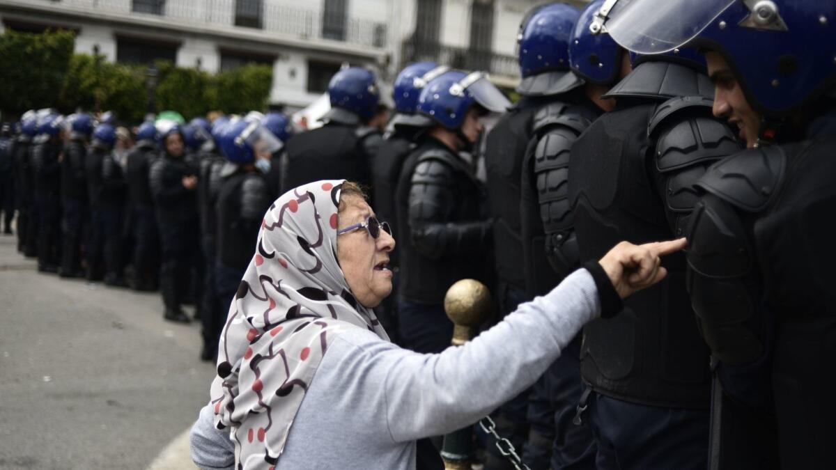 An Algerian woman talks to a member of the security forces blocking access to a protest area in Algiers, the capital on April 10.
