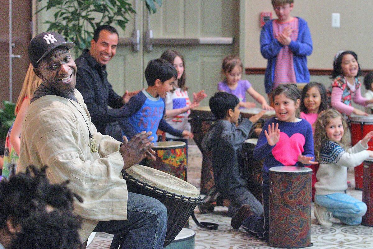 Drummer Marcus Miller, left, along with a group of children and parents, create a beat at family night at the Buena Vista Branch Library in Burbank on Thursday, March 31, 2016. Miller brought over 35 drums for just about that many children in attendance to play and make rhythms with.