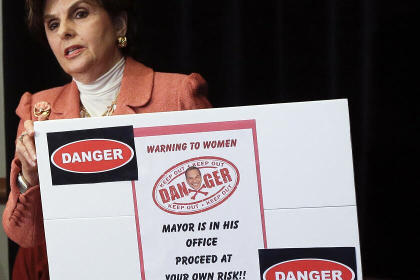 Attorney Gloria Allred holds a sign alluding to San Diego Mayor Bob Filner during a news conference on Tuesday in San Diego.