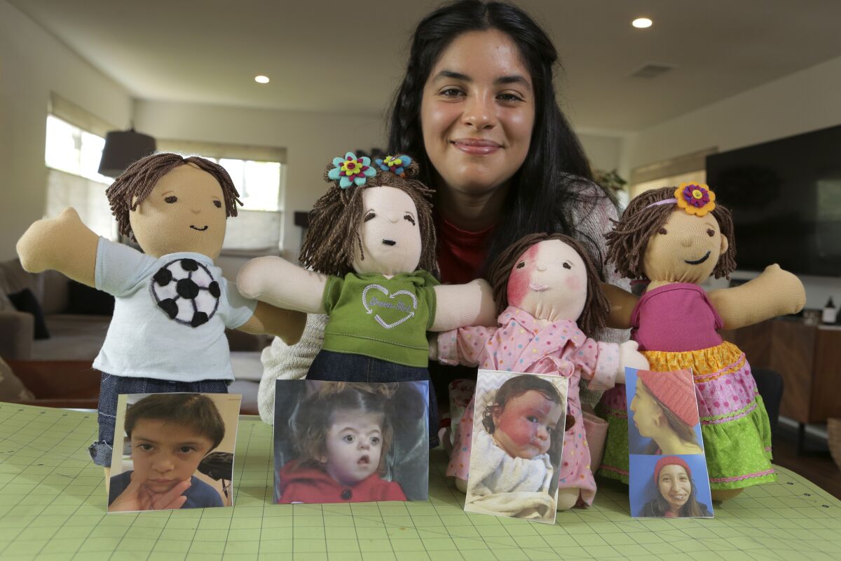 Ariella Pacheco shows the four dolls she made that mimic the unique characteristics of young people with medical issues  