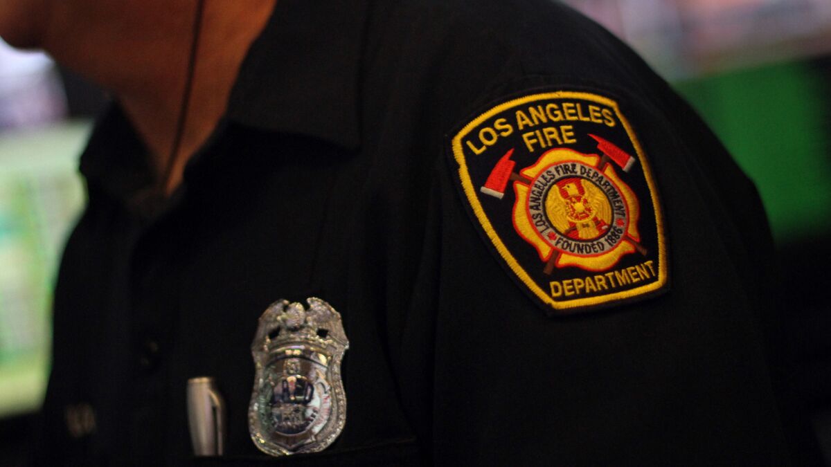 A Los Angeles firefighter wears a department badge and shoulder patch on his uniform.