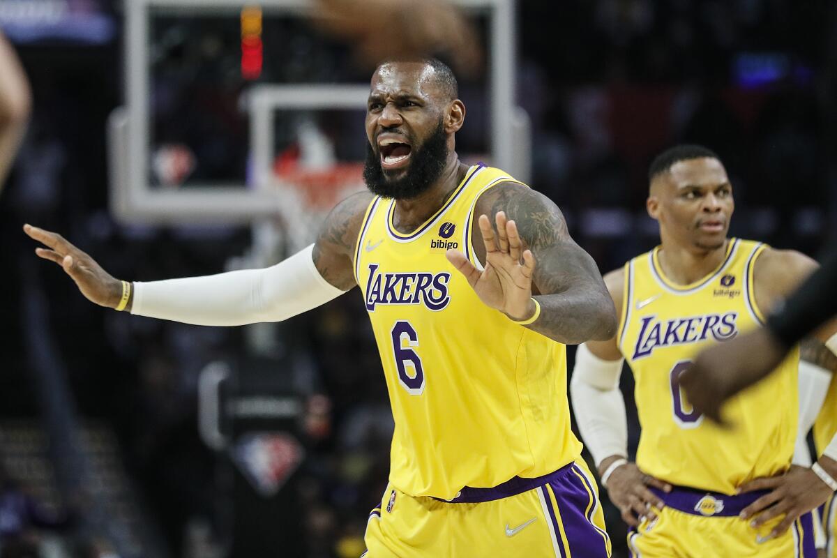 Lakers forward LeBron James questions an official's call with Russell Westbrook in the background.
