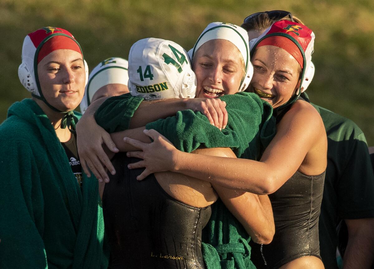 Edison's Lily Larson (14), Kenna Boehm, center, and Madie Ambrose hug it out after beating San Juan Hills.