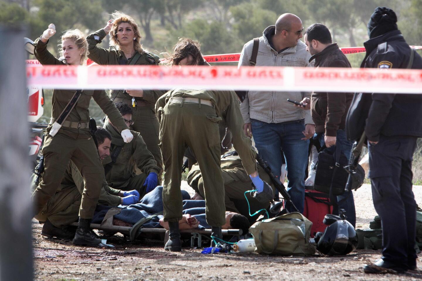An injured Palestinian suspected attacker is treated by Israeli medic soldiers after he was shot following a stabbing attack on Jan. 18, 2016 in the Tekoa settlement south of Jerusalem.