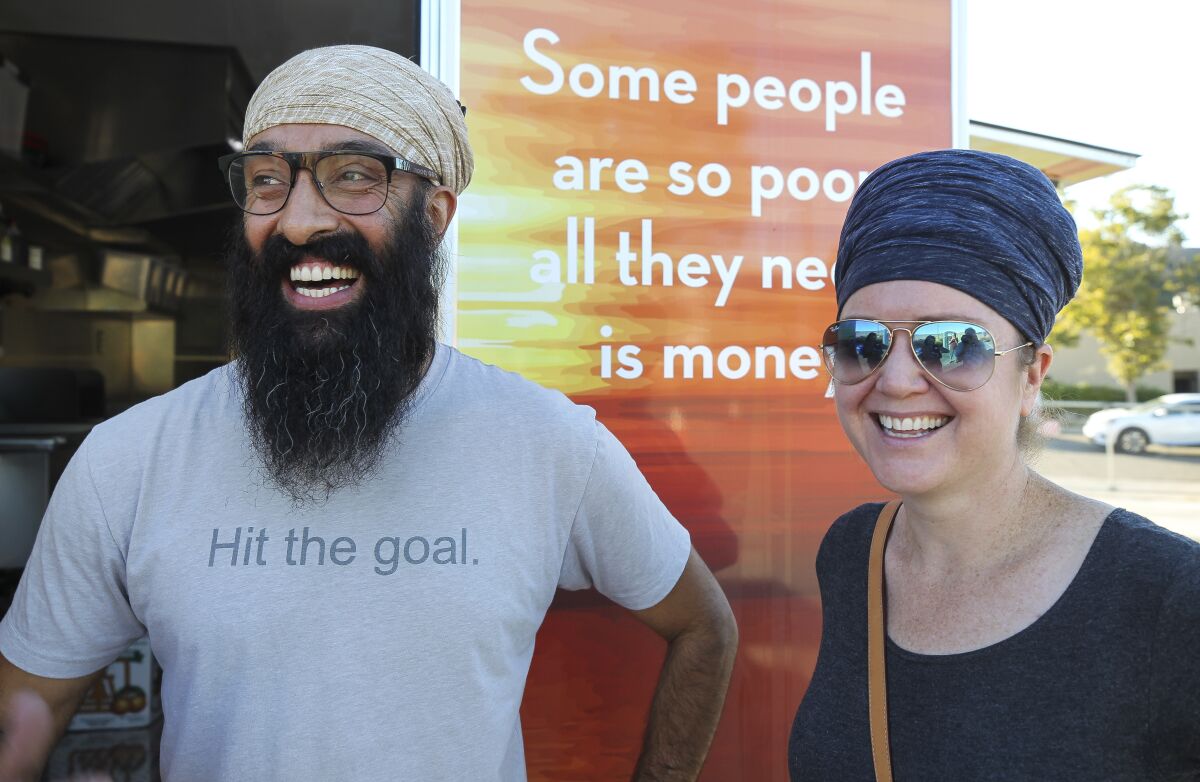 Davinder Singh and his wife Harisimran Khalsa, shown standing in front of a food trailer they launched last year, are nearing their fundraising goal to create mobile showers for homeless people in San Diego County.